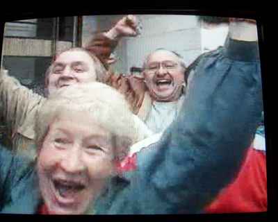 Same four people smiling, waving arms and looking towards the camera