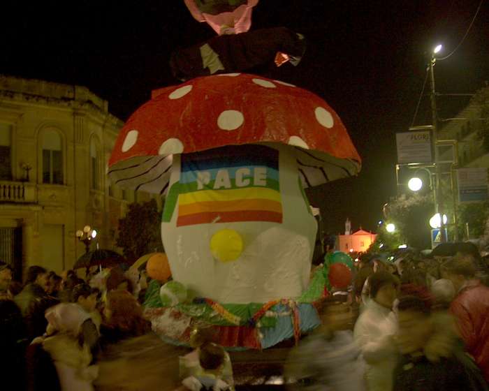 Peace flag with multi-coloured rainbow stripes, text 'PACE' on a carnival float in Ostuni, Puglia, Italy March 2003