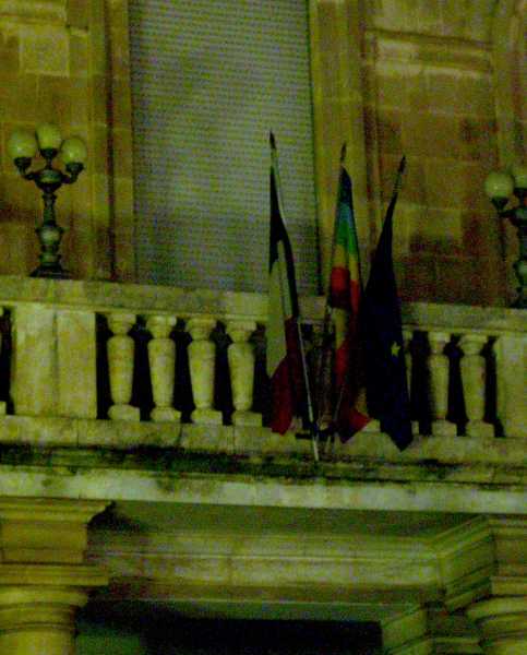 Peace flag with multi-coloured rainbow stripes, hung with EU flag and the Italian flag, in Ostuni, Puglia, Italy March 2003