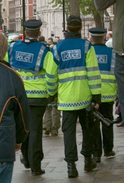 Policeman holding a camera at Palestine demonstration, London, 20 May 2006