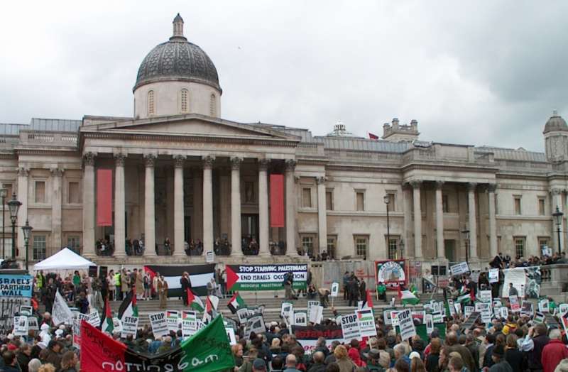Palestine demonstration, crowds at Trafalgar Square, London, 20 May 2006.  One banner says 'STOP STARVING PALESTINIANS END ISRAELS OCCUPATION' and another says 'ISRAEL'S APARTHEID WALL'.
